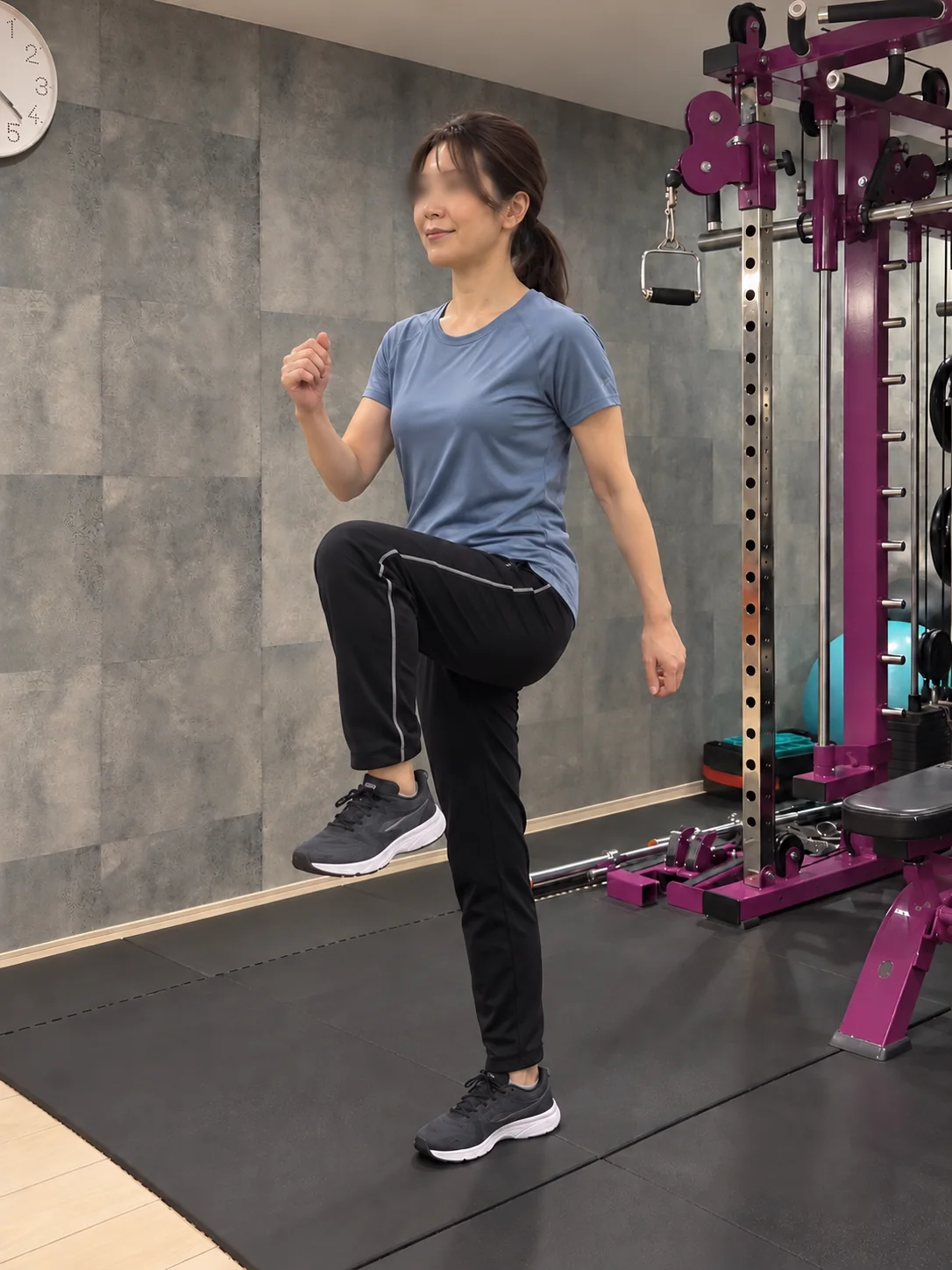 スタジオで膝を高く上げて足踏みをする女性